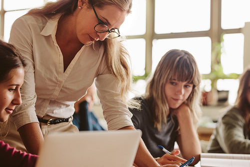 Female lecturer helping student during her class