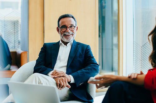 Senior businessman smiling during a meeting in a modern office setting