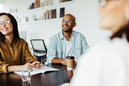 Creative business people listening to a group discussion in a meeting