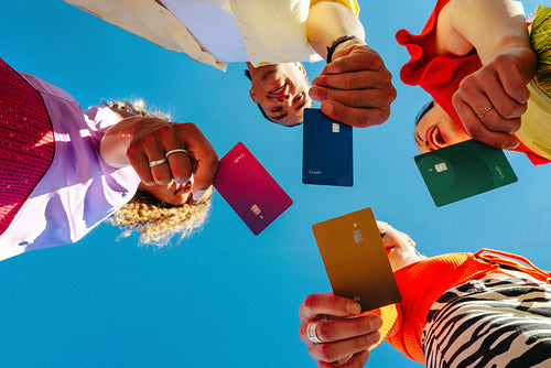Young adults display colorful credit cards for youth banking outdoors