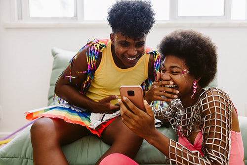 Friends celebrate carnival with colorful costumes indoors