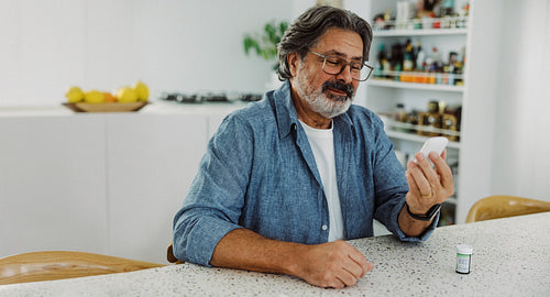 Diabetes patient checks a glucose meter in kitchen