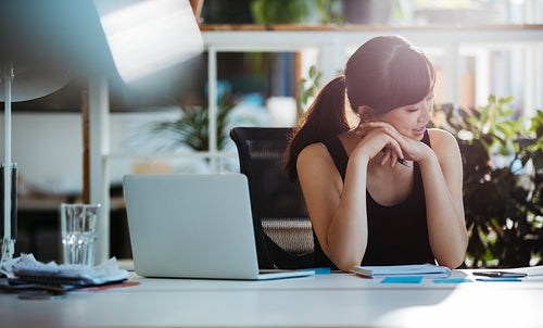 Businesswoman going through paperwork in office