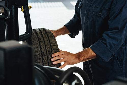 Mechanic checking car tire condition