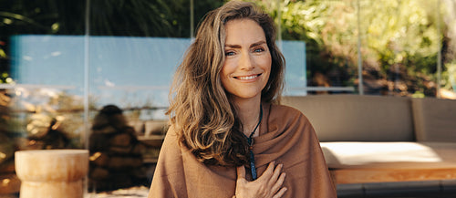 Cheerful senior woman smiling while wearing a crystal necklace
