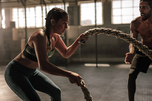 Young woman working out with battle ropes