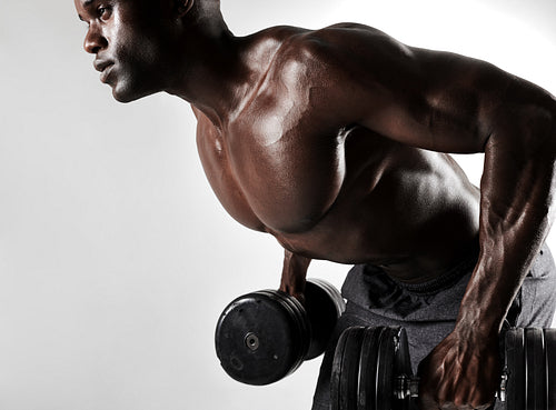 Young man working out with heavy dumbbells