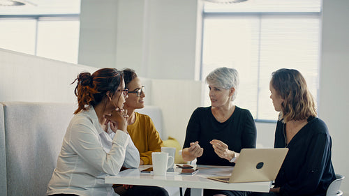 Senior businesswoman sharing her ideas with team in a cafeteria