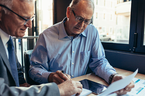 Senior partners at cafe working on a project
