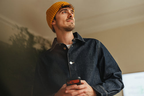 Creative professional pauses mid text in modern office