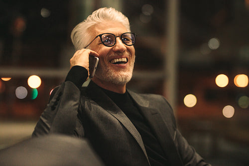 Senior businessman talking on mobile phone in office