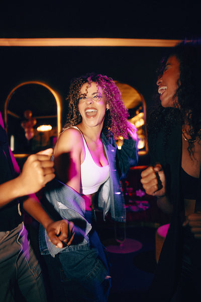 Friends enjoying a lively night out dancing and laughing in a club