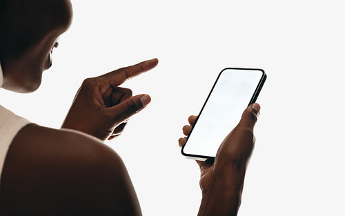 Person making zoom gesture on smartphone with blank screen for mockups
