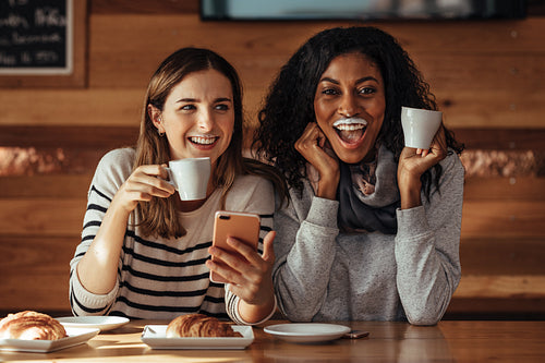 Friends sitting in a cafe drinking coffee