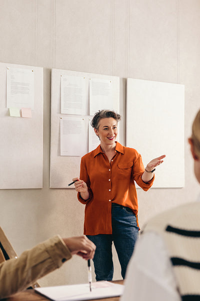 Cheerful businesswoman pitching her idea to her team in an office