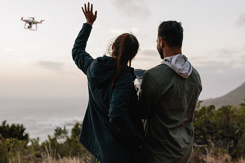 Couple in countryside talking self photograph with flying drone