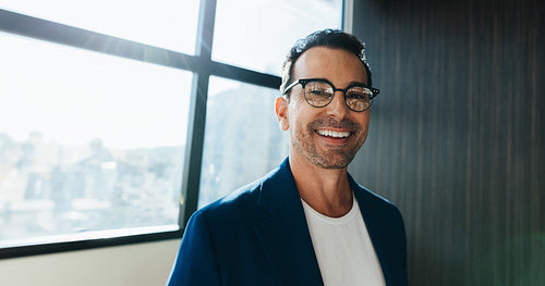 Man smiling in business portrait near window in office