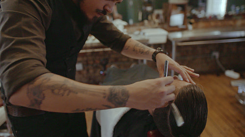 Barber grooming beard of customer