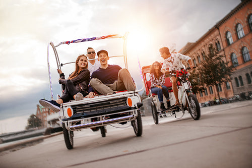 Young friends going on tricycle ride through the city