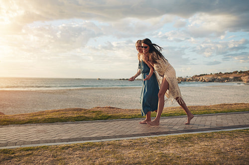 Best friends walking on pathway along a beach