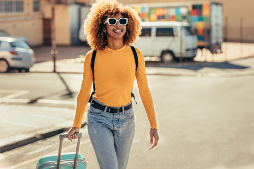 Cheerful woman traveller walking on street