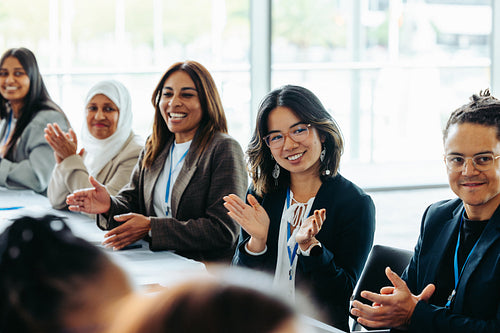 Diverse business team in a meeting exchanging feedback and applause, fostering collaboration and success