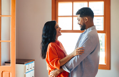 Smiling couple enjoying a moment together indoors near bright window