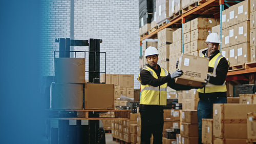 Putaway in a fulfilment warehouse: Logistics workers offload goods from a pallet truck