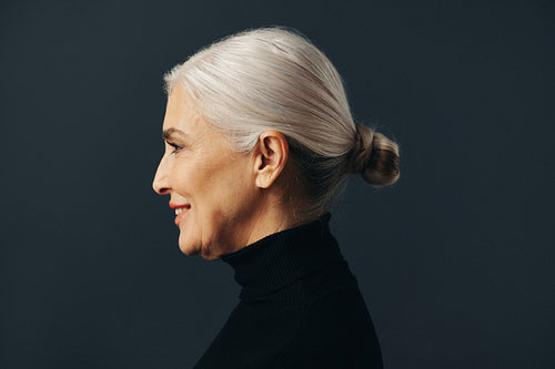 Mature business woman with grey hair standing in studio