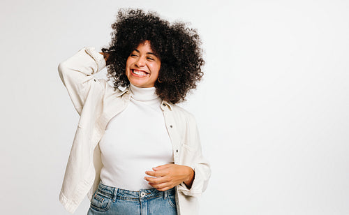 Beautiful woman with Afro hair smiling happily in a studio