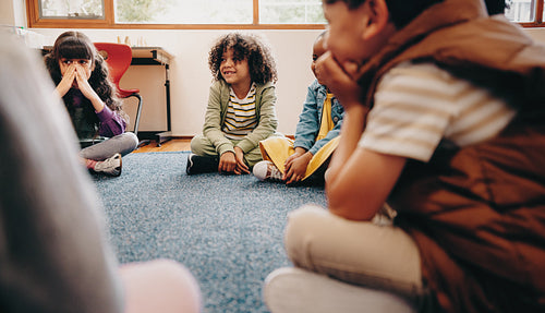 Group of children sitting in a circle in a classroom