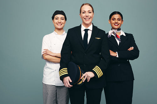 Three women from different service occupations standing in a stu