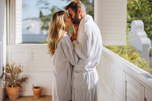 Passionate couple kissing on a balcony
