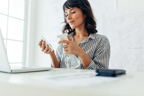 Woman sanitising her work desk