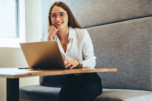 Professional woman smiling at the camera in a modern workspace