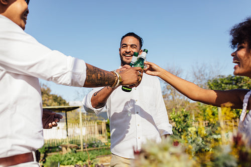 Multi-ethnic millennials having beers at party