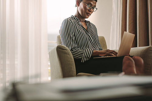 Businesswoman on business trip working from hotel room