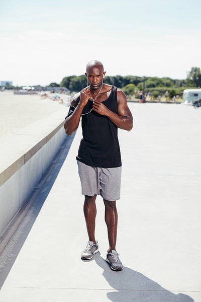 Young man outside listening to music on earphones