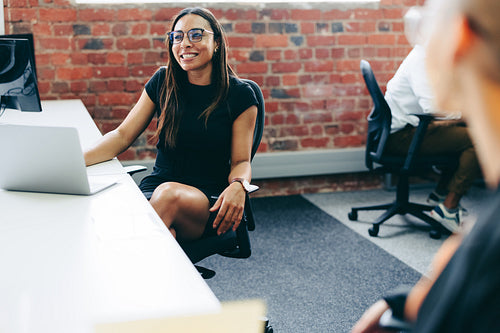 Businesswoman smiling while working with her colleagues in the o