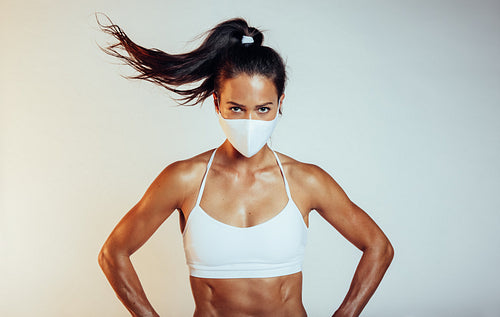 Muscular sportswoman with face mask