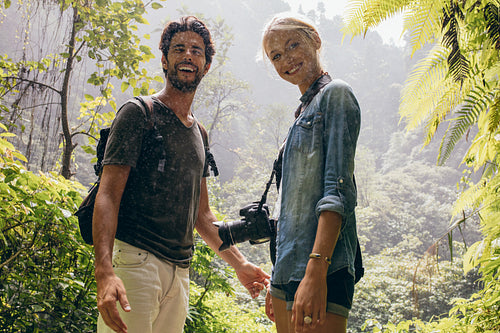 Hiker couple standing together during rain in the forest