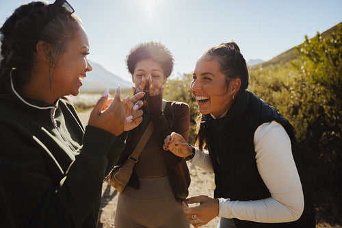Friends laughing outdoors in sunny weather