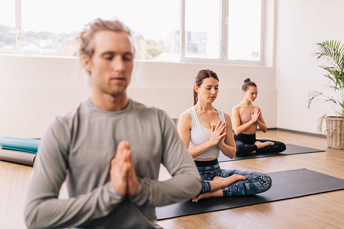 Group of people meditating in a yoga studio