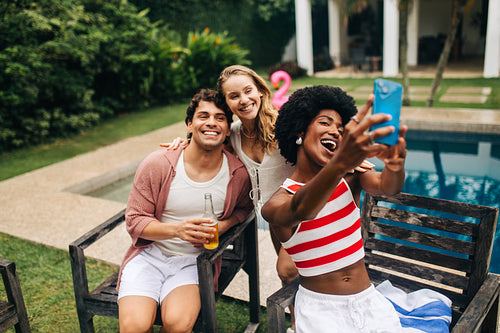 Friends take a fun selfie by the poolside