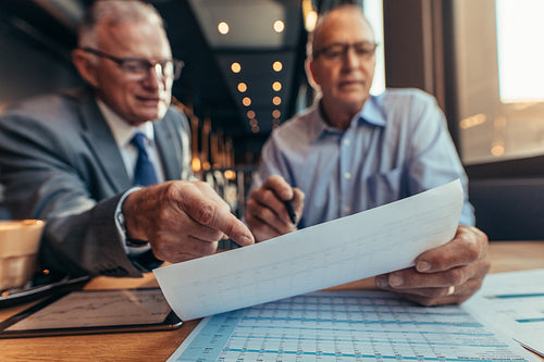 Businessmen working over budget of new project at cafe
