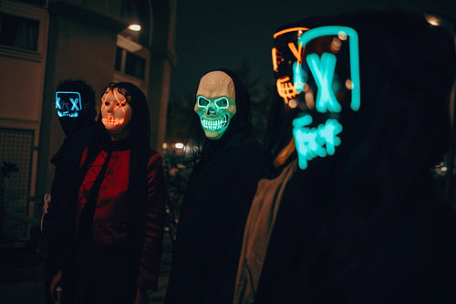 People in illuminated masks gathered during a nighttime city event