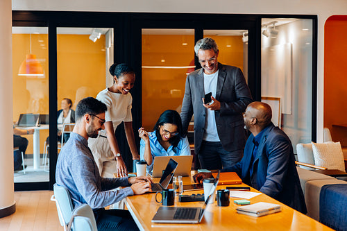 Group of professionals engaged in an active discussion in a bright office setting
