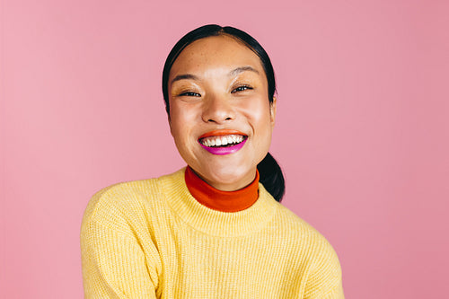 Confident young woman smiling at the camera wearing a two toned lipstick