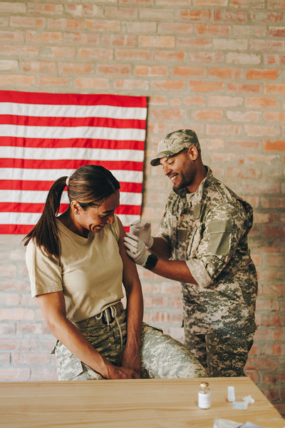 United States military nurse vaccinating a servicewoman