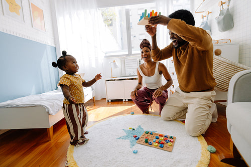Family playtime with parents and toddler at home